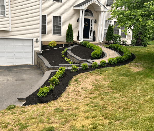 mulch ground cover, shrubs, planters, retaining walls and a paver path